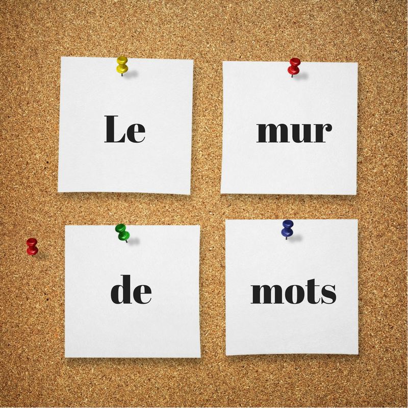 Image d'un babillard et des papiers avec les mots "le", "mur", "de" et "mots"