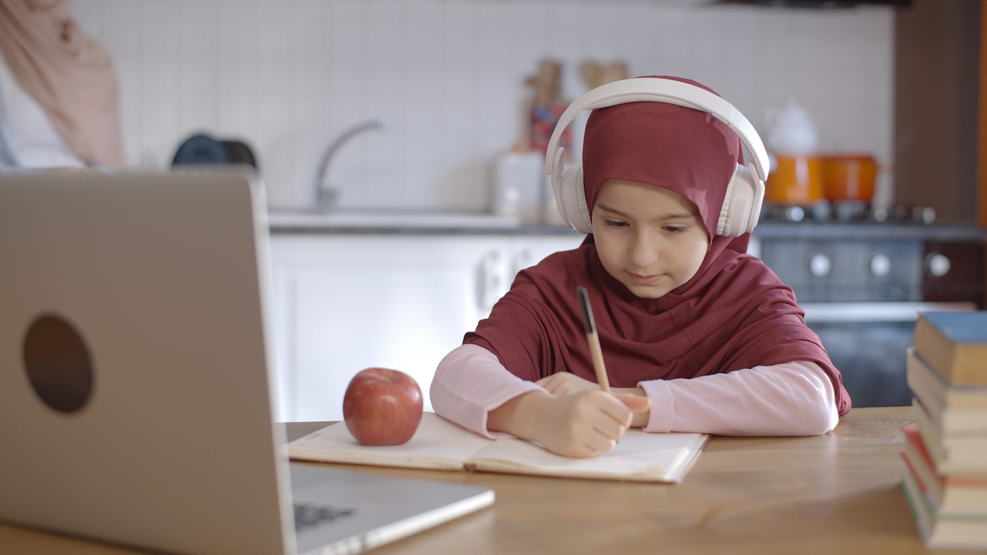 Image d'une petite fille muslemanne devant son ordinateur