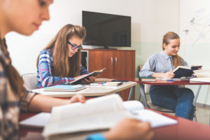 Trois adolescentes qui travaillent à des pupitres